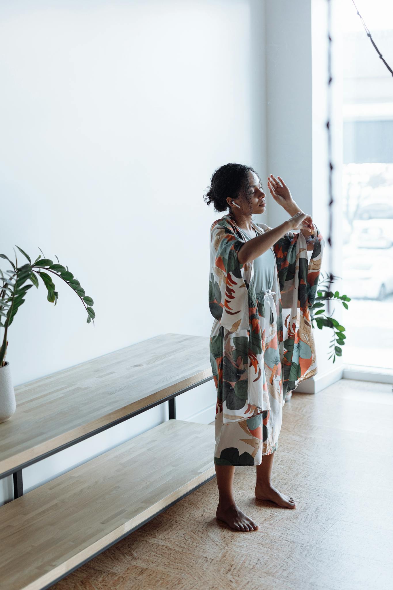 Young woman embracing relaxation and mindfulness indoors, practicing yoga by a window.